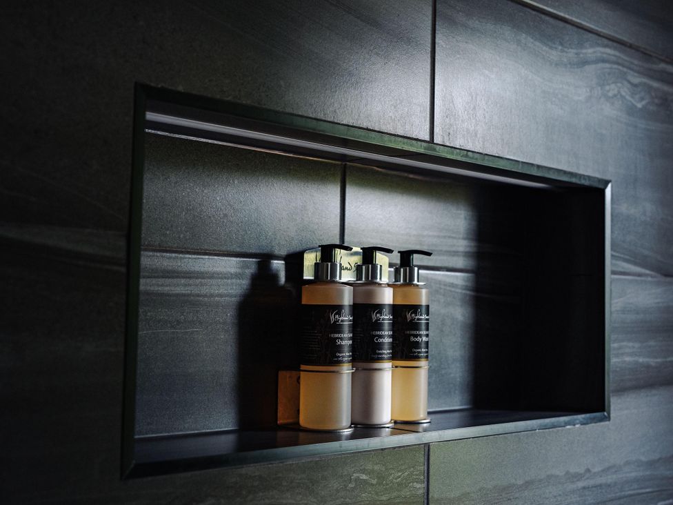 A bathroom shelf with shampoo, conditioner, and body wash at Heilan Roo near Killiecrankie and Pitlochry and Blair Atholl