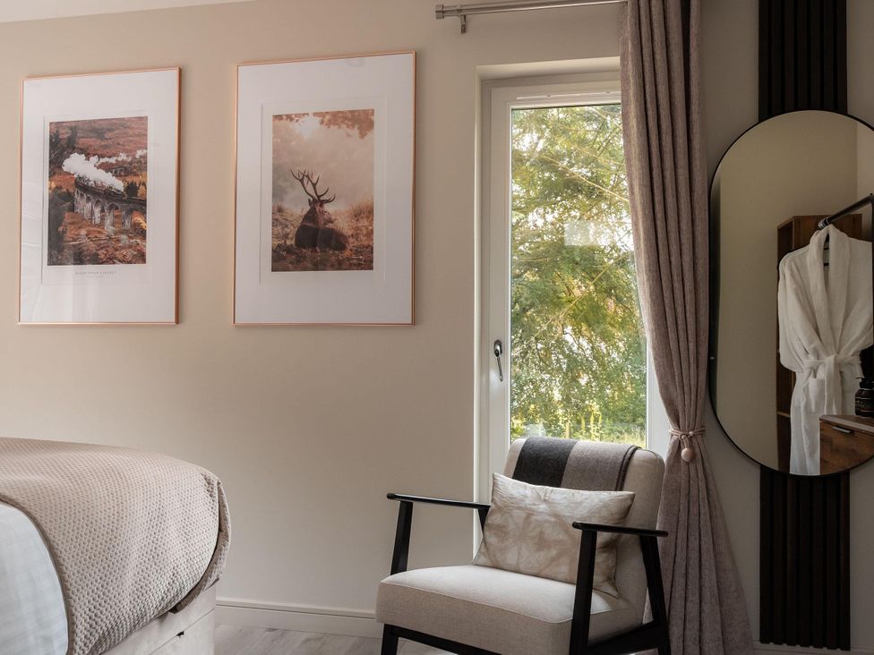 A bedroom with framed pictures and a window at Heilan Roo near Killiecrankie, Pitlochry and Blair Atholl