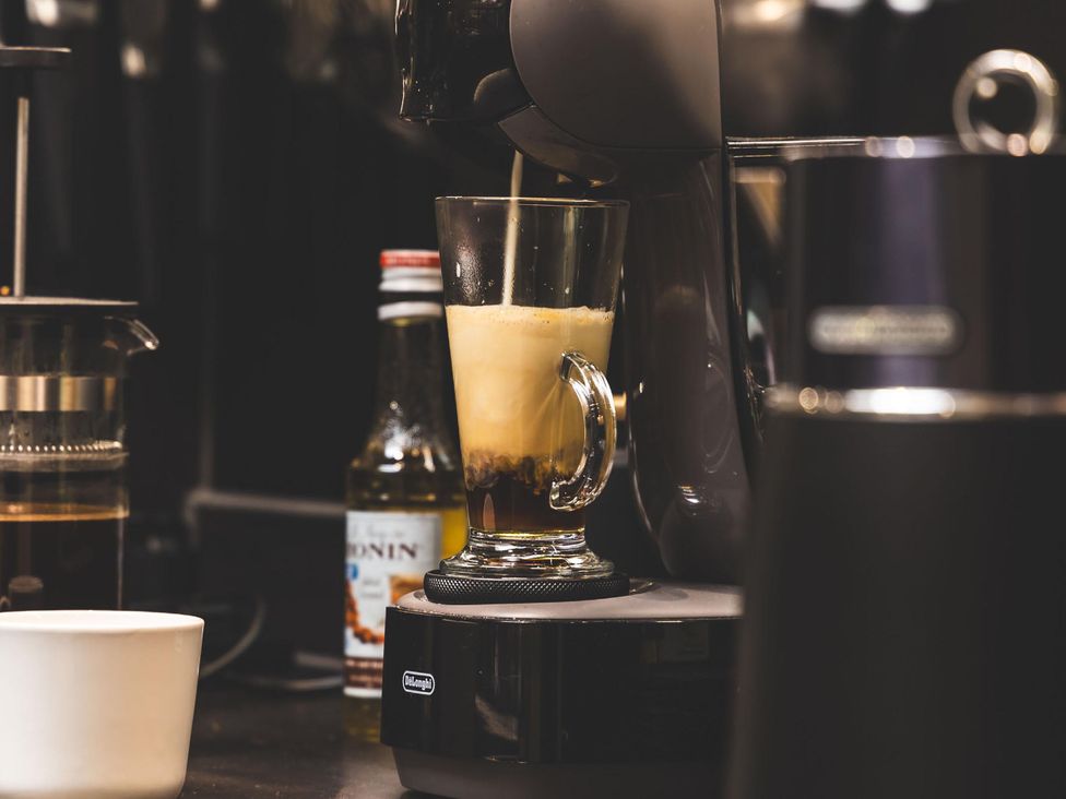 A coffee maker pouring coffee into a glass cup in a kitchen at Heilan Roo near Killiecrankie and Pitlochry and Blair Atholl
