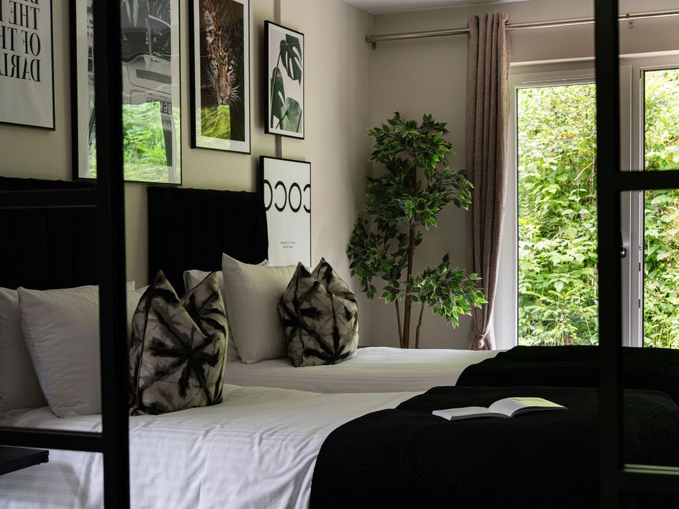 A bedroom with two beds and wall art at Heilan Roo in Killiecrankie near Pitlochry and Blair Atholl