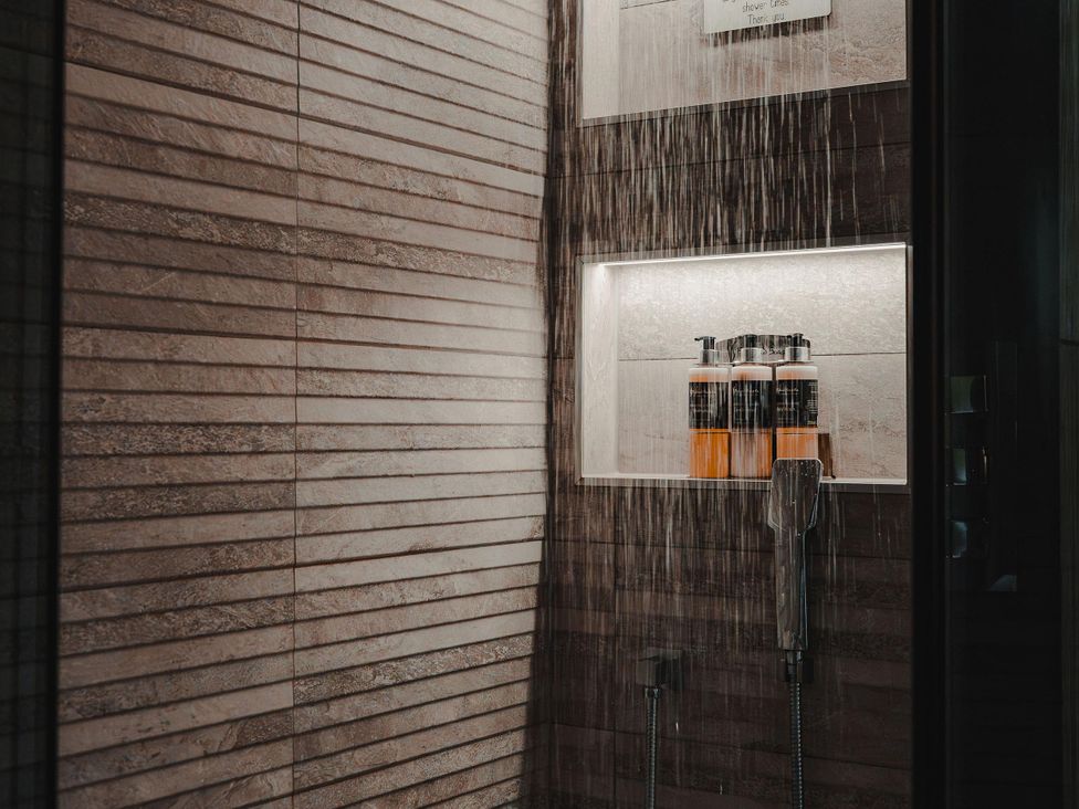 A shower with shampoo bottles on a shelf at Heilan Roo, Killiecrankie near Pitlochry and Blair Atholl