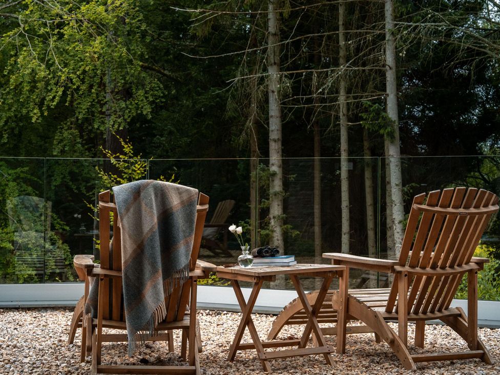 An outdoor seating area with chairs and a table at Heilan Roo in Killiecrankie near Pitlochry and Blair Atholl