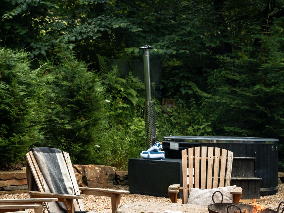 An outdoor area with chairs and a hot tub at Heilan Roo in Killiecrankie near Pitlochry and Blair Atholl