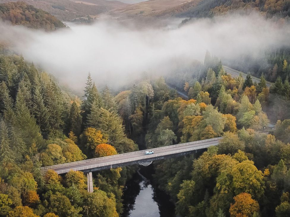 An aerial view of a bridge over a river surrounded by forest at Heilan Roo, Killiecrankie near Pitlochry and Blair Atholl