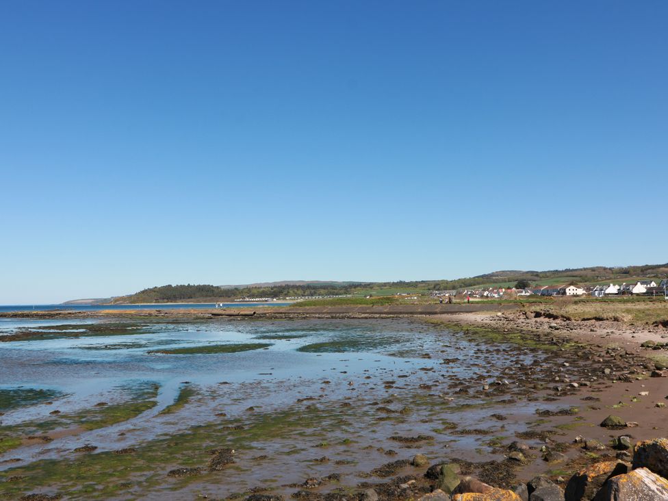 A coastal view with rocks and houses at Honesty Cottage Maidens