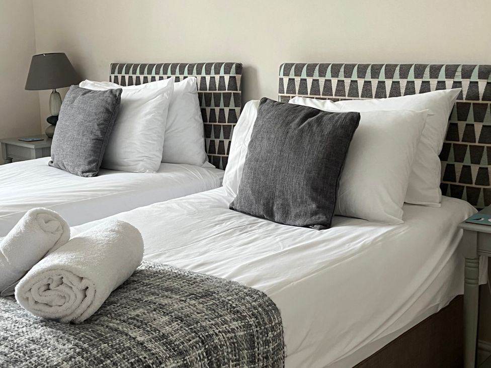 A bedroom with two beds and pillows at Seasides in Weymouth