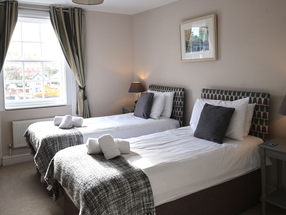 A bedroom with two beds and a window at Seasides in Weymouth