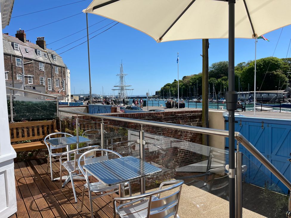 An outdoor seating area with tables and chairs at Seasides in Weymouth