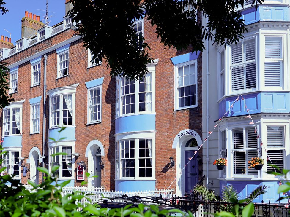 A view of a row of houses with a sign at Sea Sides in Weymouth