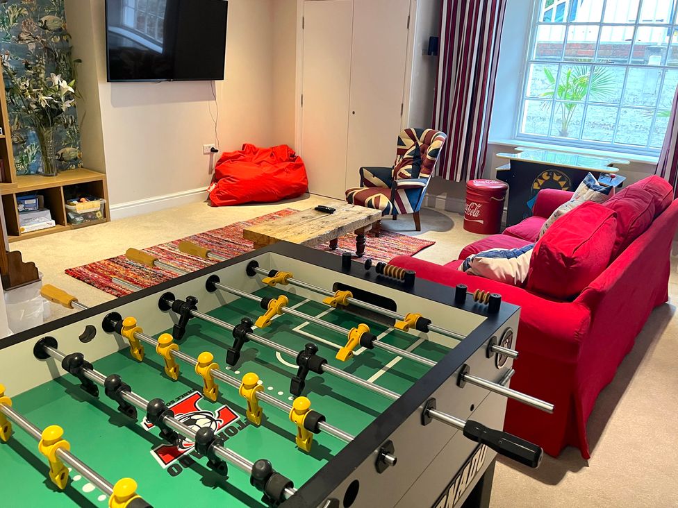 A living room with a foosball table and a television at Seasides in Weymouth