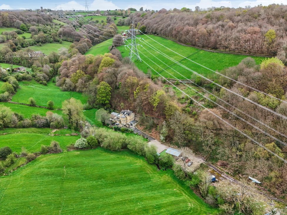 A house near power lines in a green landscape at Belvedere Farm Hipperholme