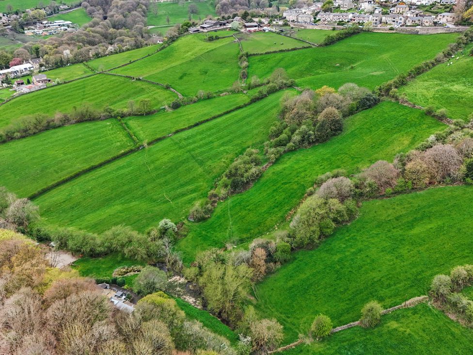 An aerial view of green fields and scattered houses at Belvedere Farm in Hipperholme