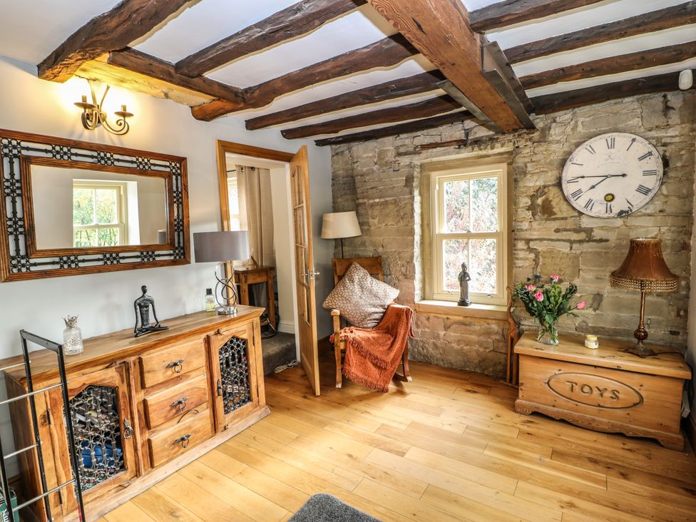 A snug with a wooden table and a chair at Belvedere Farm in Hipperholme