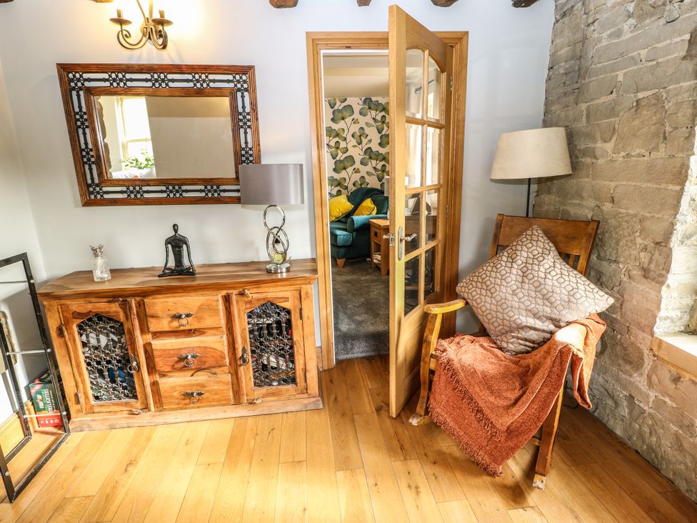 A living room with a table, chair, and mirror at Belvedere Farm in Hipperholme