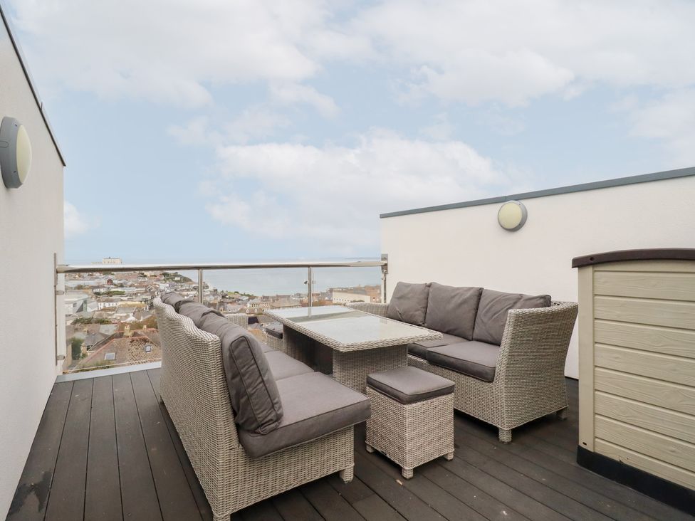 An outdoor seating area with a table and chairs at 5 Quay Court in Newquay