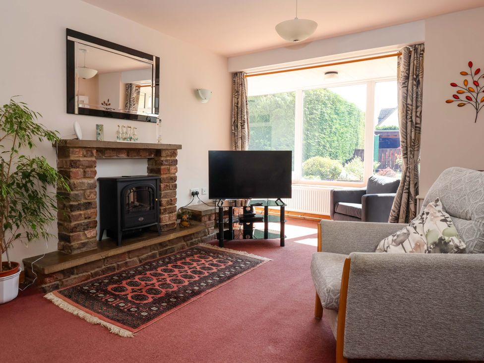 A living room with a fireplace and television at 3 Springhaven in Hampsthwaite