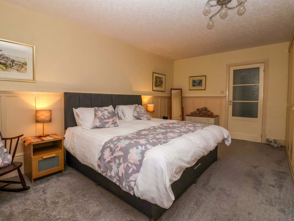 A bedroom with a bed and rocking chair at 3 Springhaven in Hampsthwaite