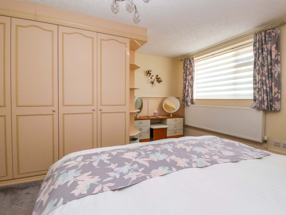 A bedroom with a wardrobe and dressing table at 3 Springhaven in Hampsthwaite