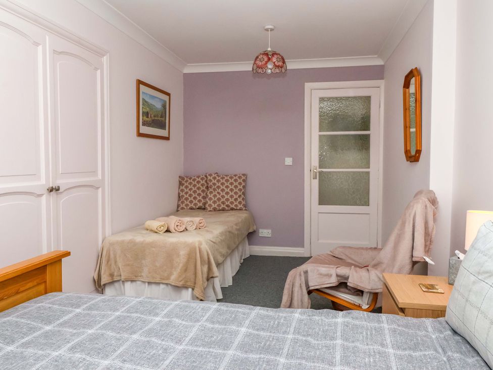 A bedroom with two beds and a bedside table at 3 Springhaven in Hampsthwaite