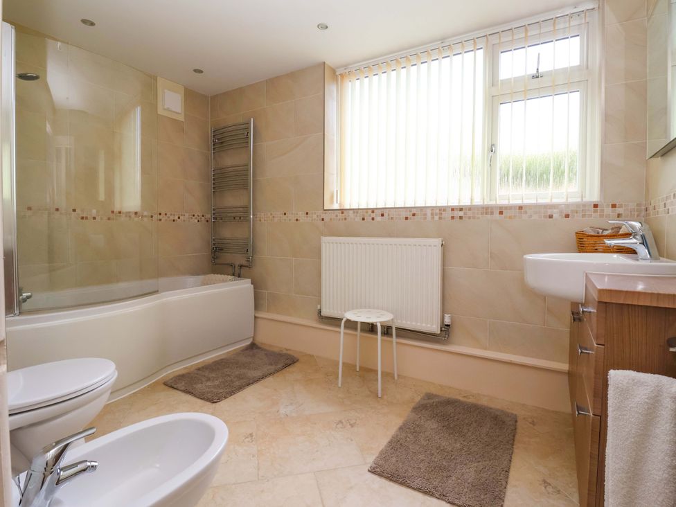A bathroom with a bathtub, toilet and sink at 3 Springhaven in Hampsthwaite