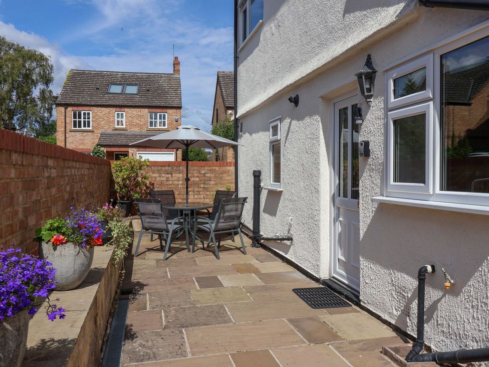 A garden with a dining table and chairs beneath an umbrella at 3 Springhaven in Hampsthwaite
