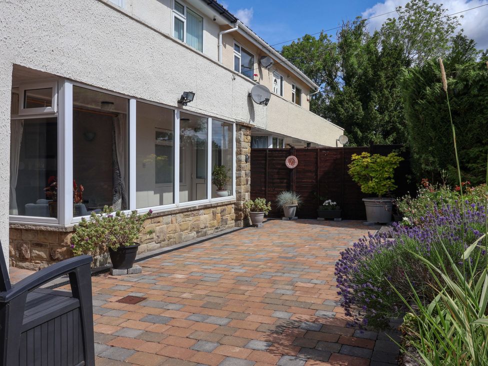 A garden with paving stones, plants, and a fence at 3 Springhaven, Hampsthwaite