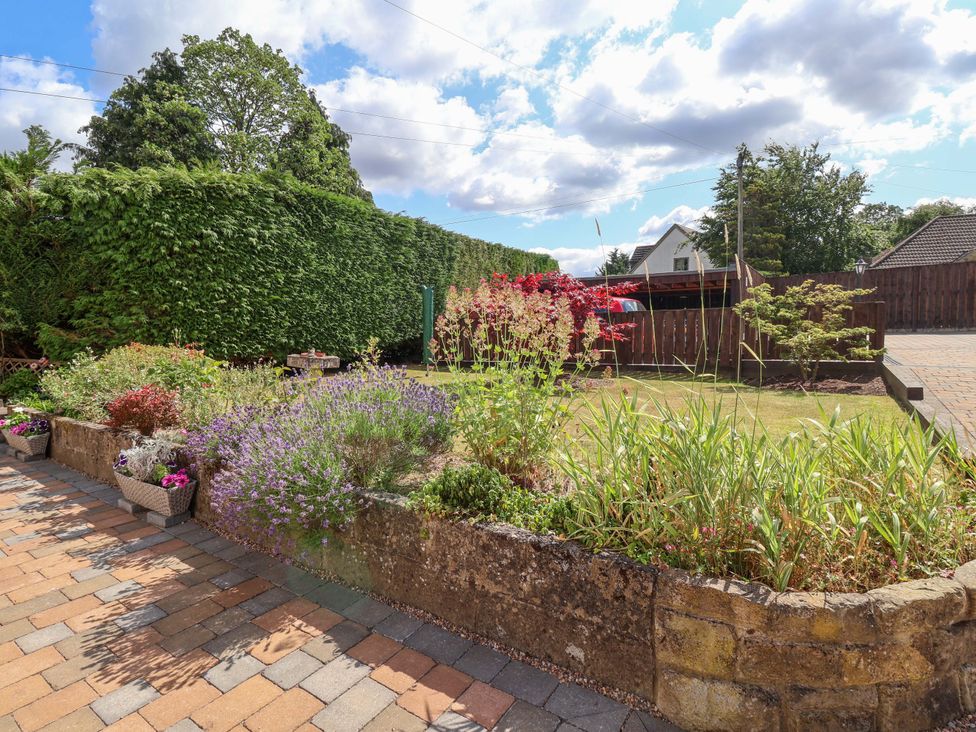 A garden with flower beds and a lawn at 3 Springhaven in Hampsthwaite