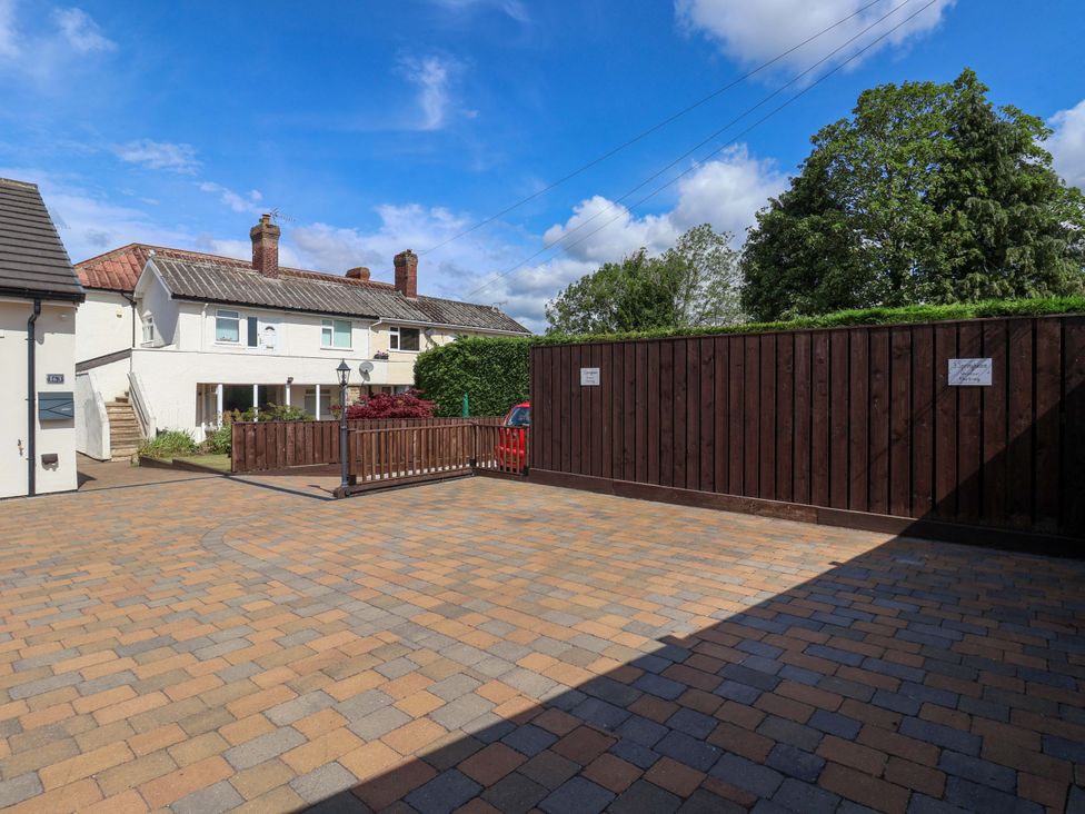 A yard with a house and a fence at 3 Springhaven in Hampsthwaite
