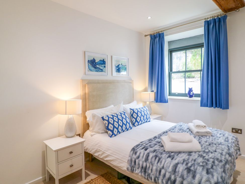 A bedroom with a bed and bedside table at 9 The Pottery in Dartmouth