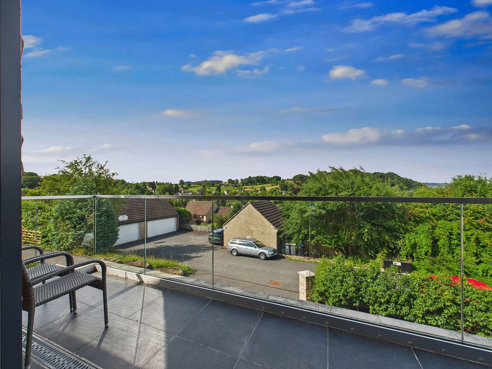 A balcony view with trees and houses at Oakwood House, Tansley near Matlock
