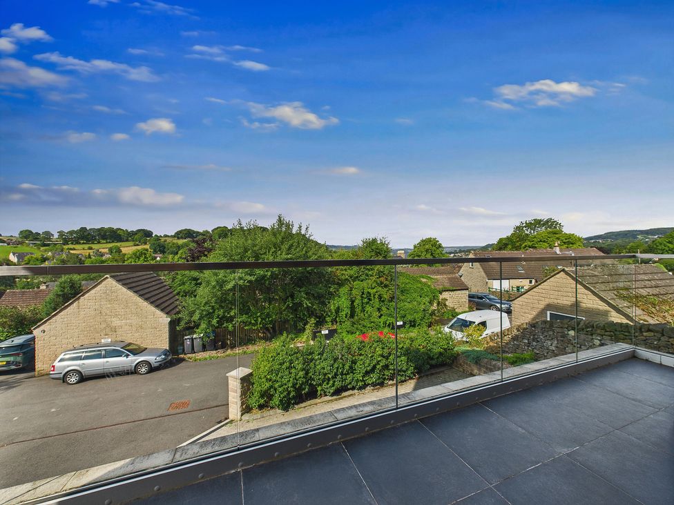 An outdoor balcony view overlooking houses and trees at Oakwood House Tansley near Matlock