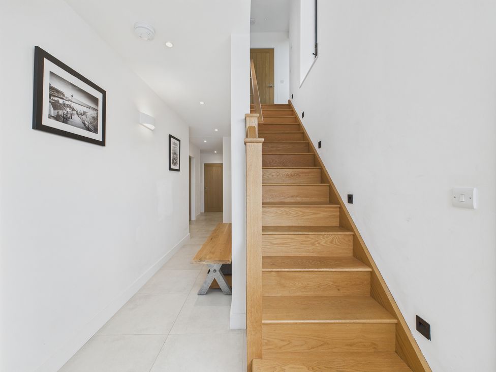 A hallway with a staircase and bench at Oakwood House in Tansley near Matlock