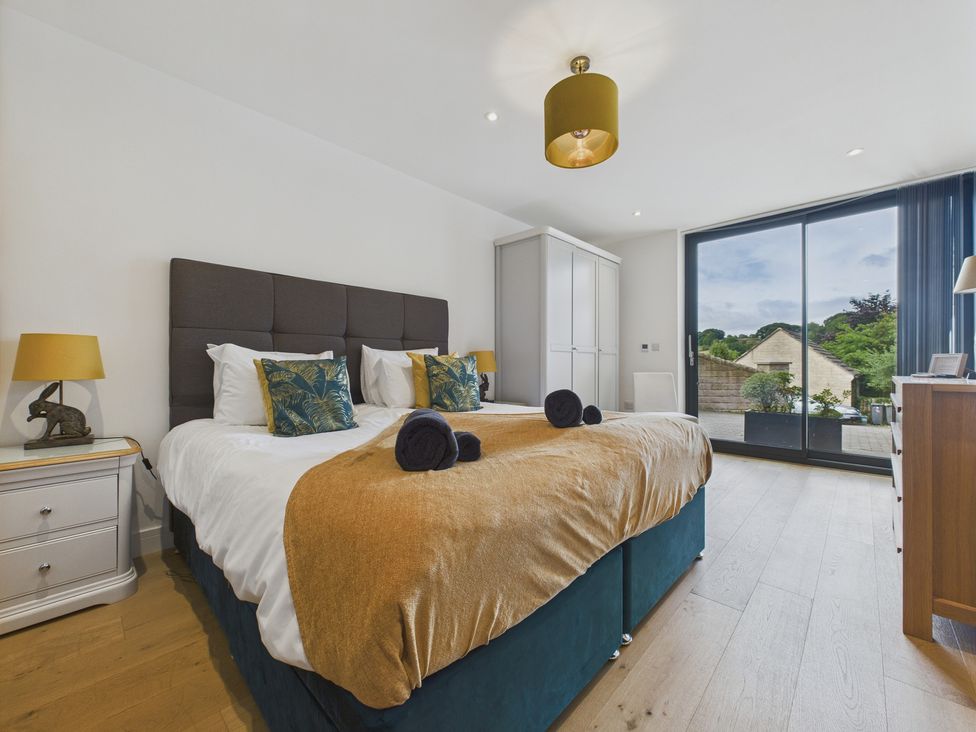 A bedroom with a bed and a sliding door at Oakwood House Tansley near Matlock