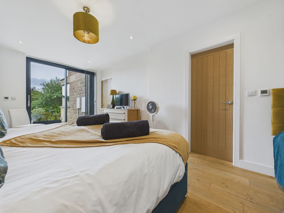 A bedroom with two beds and a television at Oakwood House in Tansley near Matlock