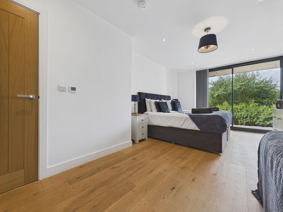 A bedroom with two beds and a window at Oakwood House in Tansley near Matlock