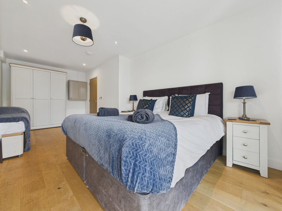 A bedroom with a large bed and wardrobe at Oakwood House in Tansley near Matlock