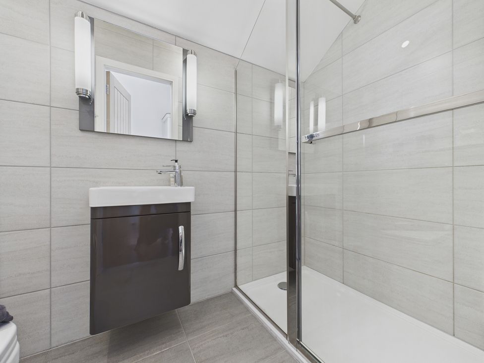 A bathroom with a shower and sink at Oakwood House in Tansley near Matlock