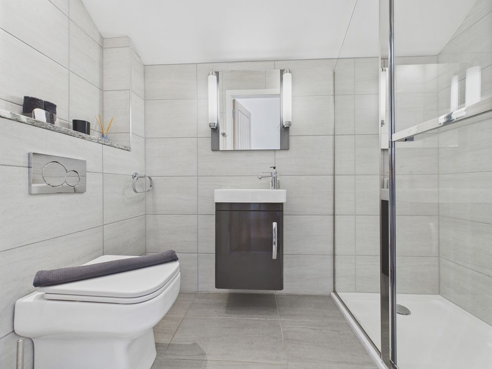 A bathroom with a sink, toilet, and shower at Oakwood House Tansley near Matlock