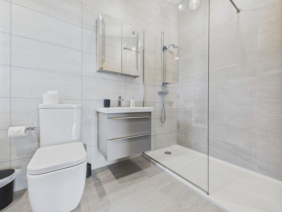 A bathroom with a toilet, sink, and shower at Oakwood House Tansley near Matlock