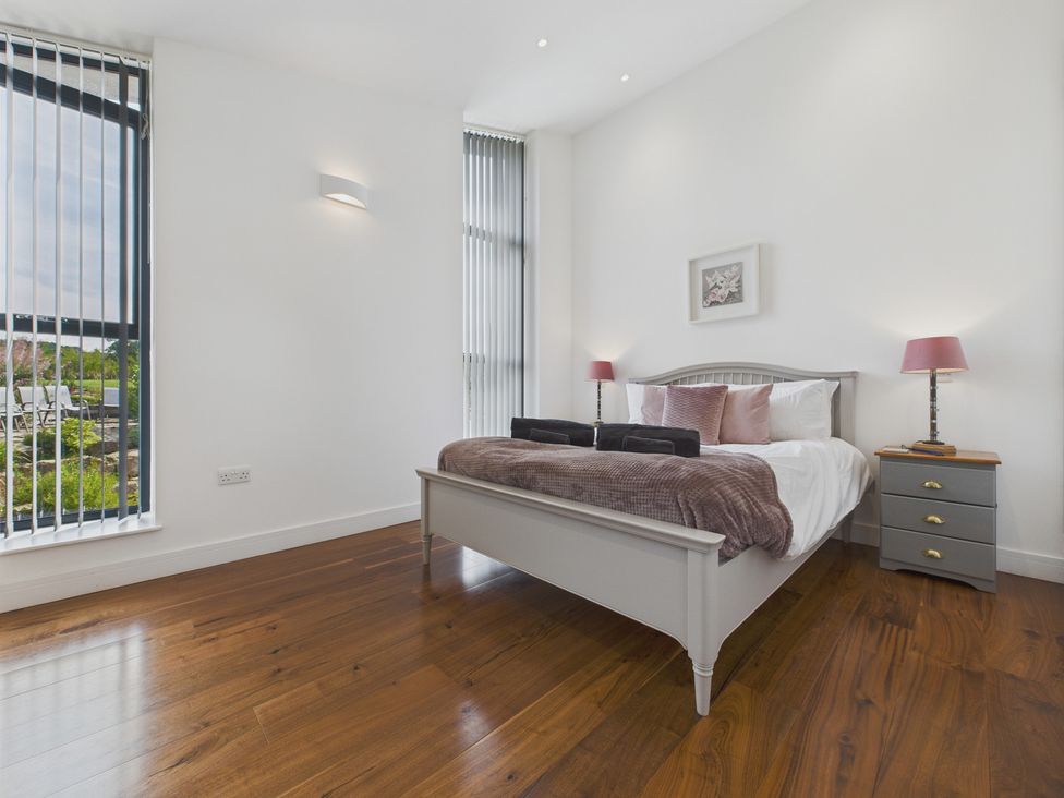 A bedroom with a bed and nightstand at Oakwood House Tansley near Matlock