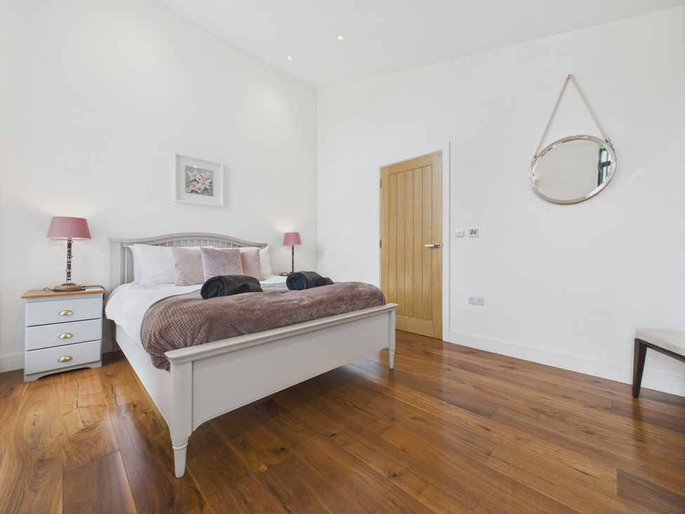 A bedroom with a bed and bedside table at Oakwood House in Tansley near Matlock