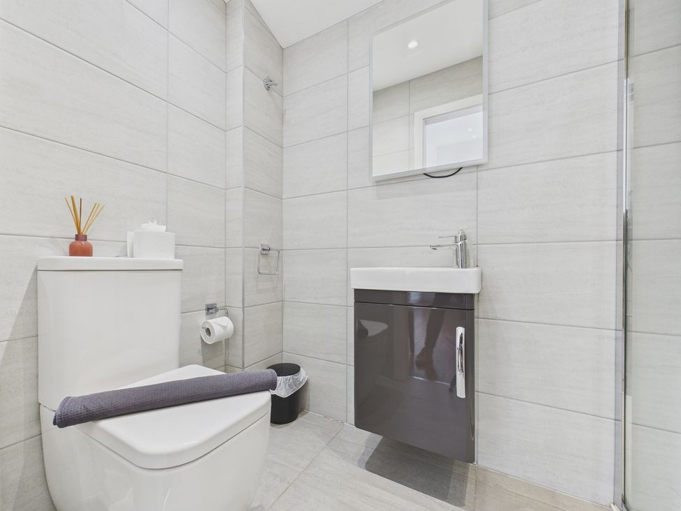 A bathroom with a toilet and sink at Oakwood House in Tansley near Matlock