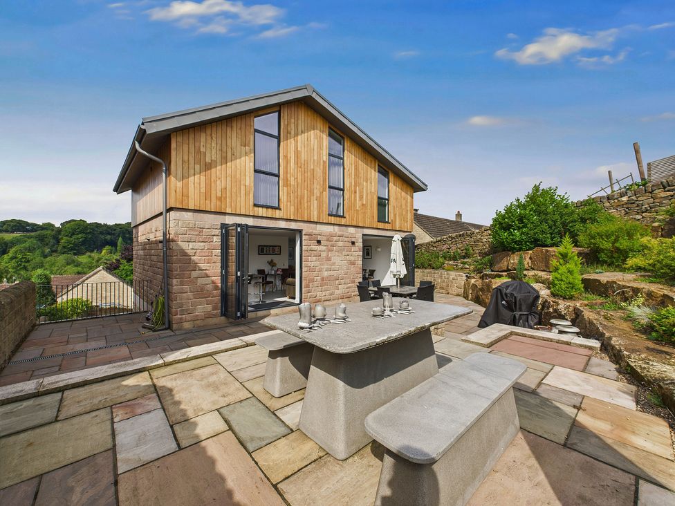 A house with a patio and outdoor dining area at Oakwood House Tansley near Matlock
