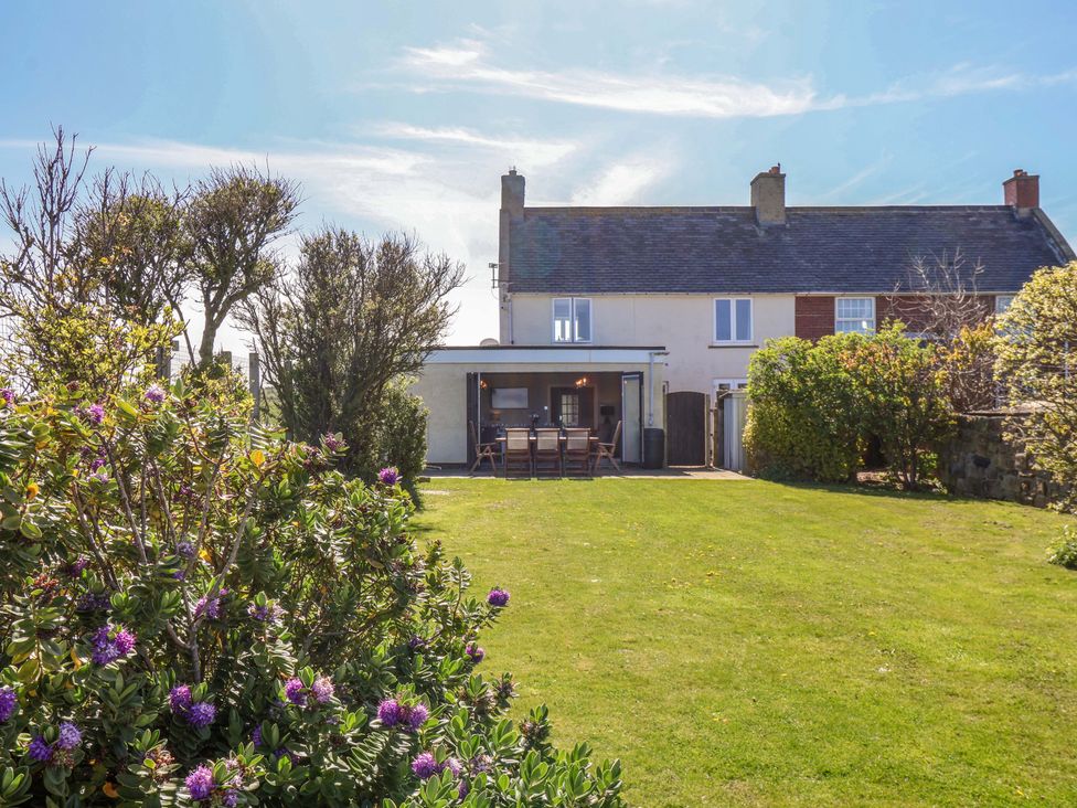 A garden with a house and dining area at Voebroch in Lythe