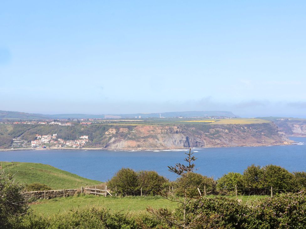 A coastal view featuring water, cliffs, and houses at Voebroch in Lythe