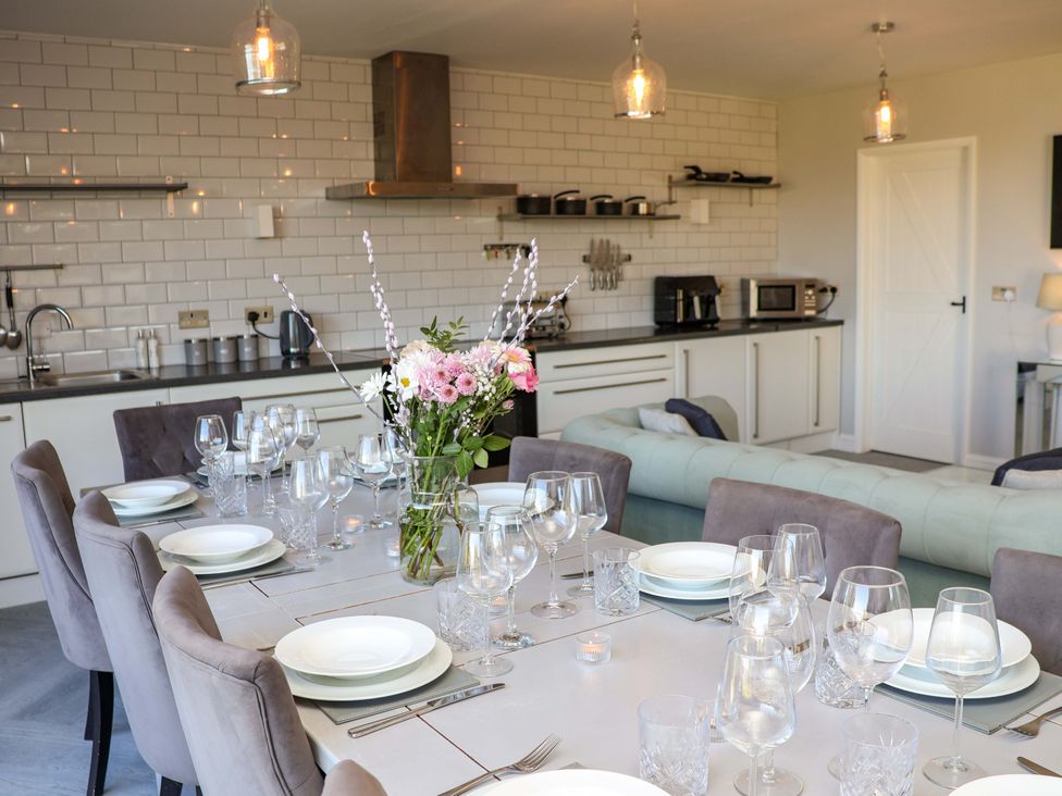 A dining room with a table set for meals at Voebroch in Lythe