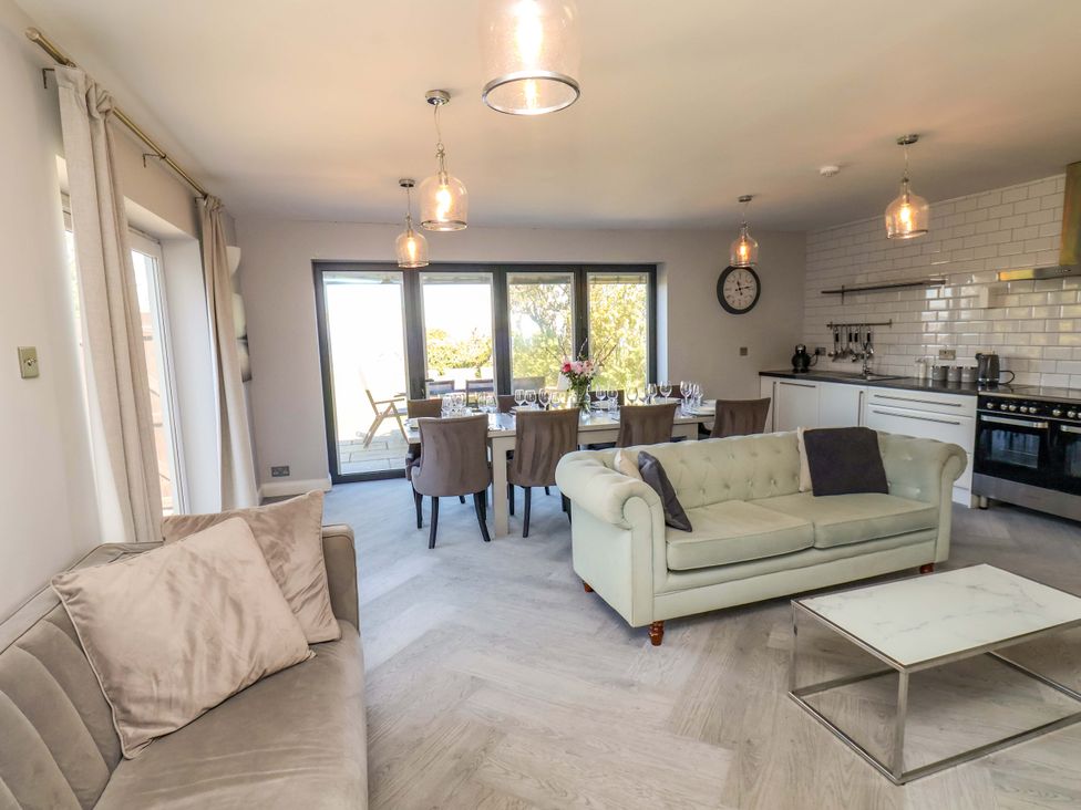 An open plan living area with a sofa and dining table at Voebroch in Lythe