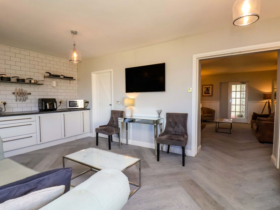 A living room with kitchen units and a television at Voebroch in Lythe
