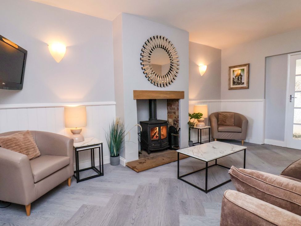 A living room with a fireplace and chairs at Voebroch in Lythe