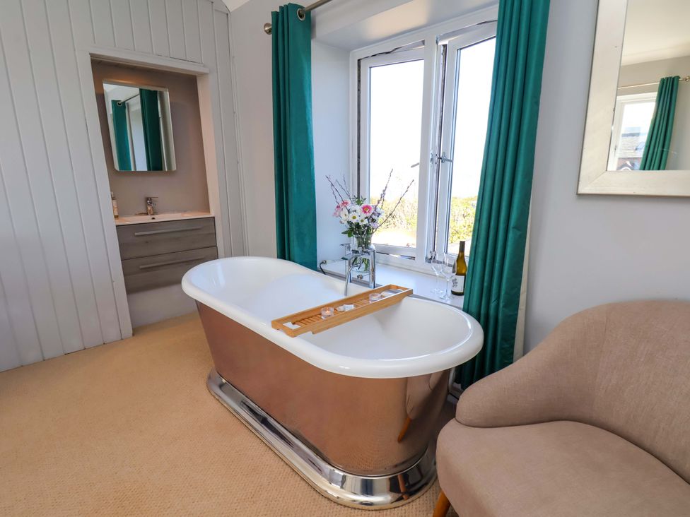 A bathroom with a freestanding bathtub and sink at Voebroch in Lythe